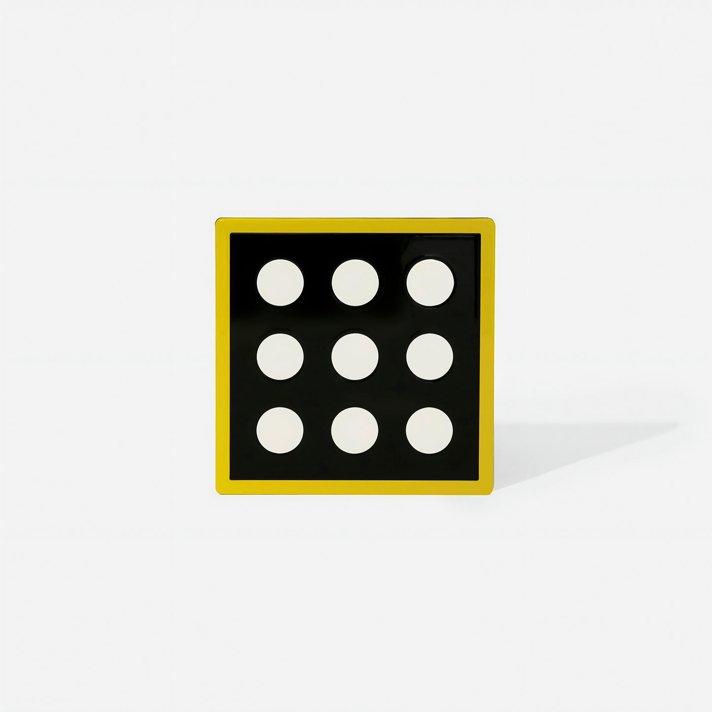 Yellow square metal coaster with nine white circular cut-outs and glossy yellow frame – handcrafted by ISUWA for modern and artistic table styling
