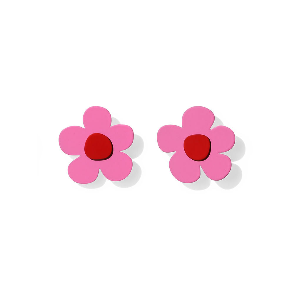 Pair of bold pink flower earrings with red centers and sculptural five-petal shapes, displayed on a white background.