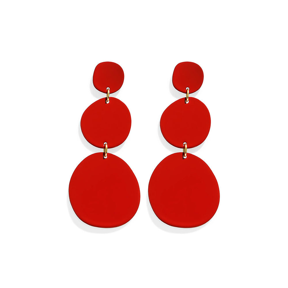 Bold red statement earrings with a triple organic circle design, photographed against a white background.

