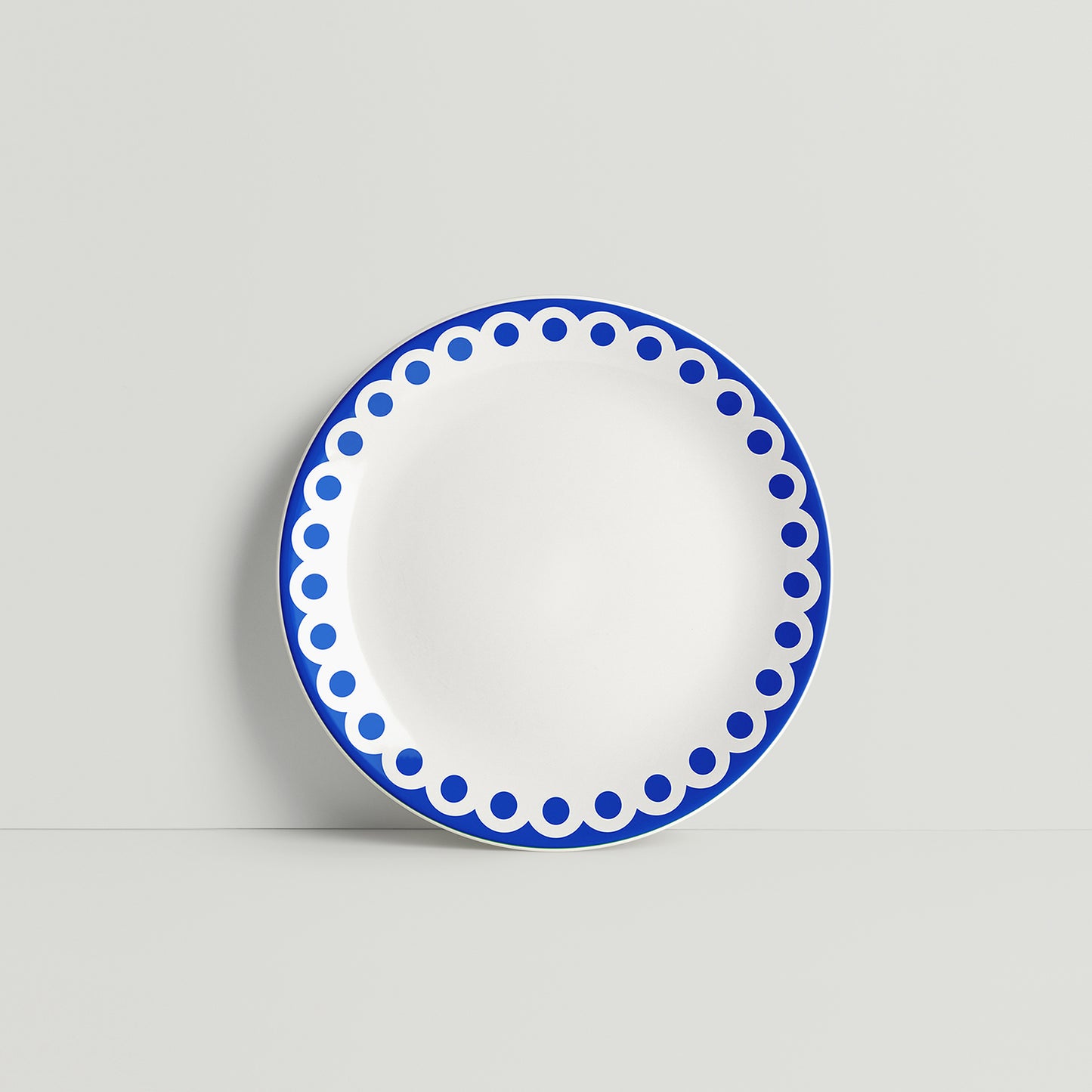 ISUWA’s navy porcelain plate with bold dotted pattern around the rim, displayed against a soft neutral background
