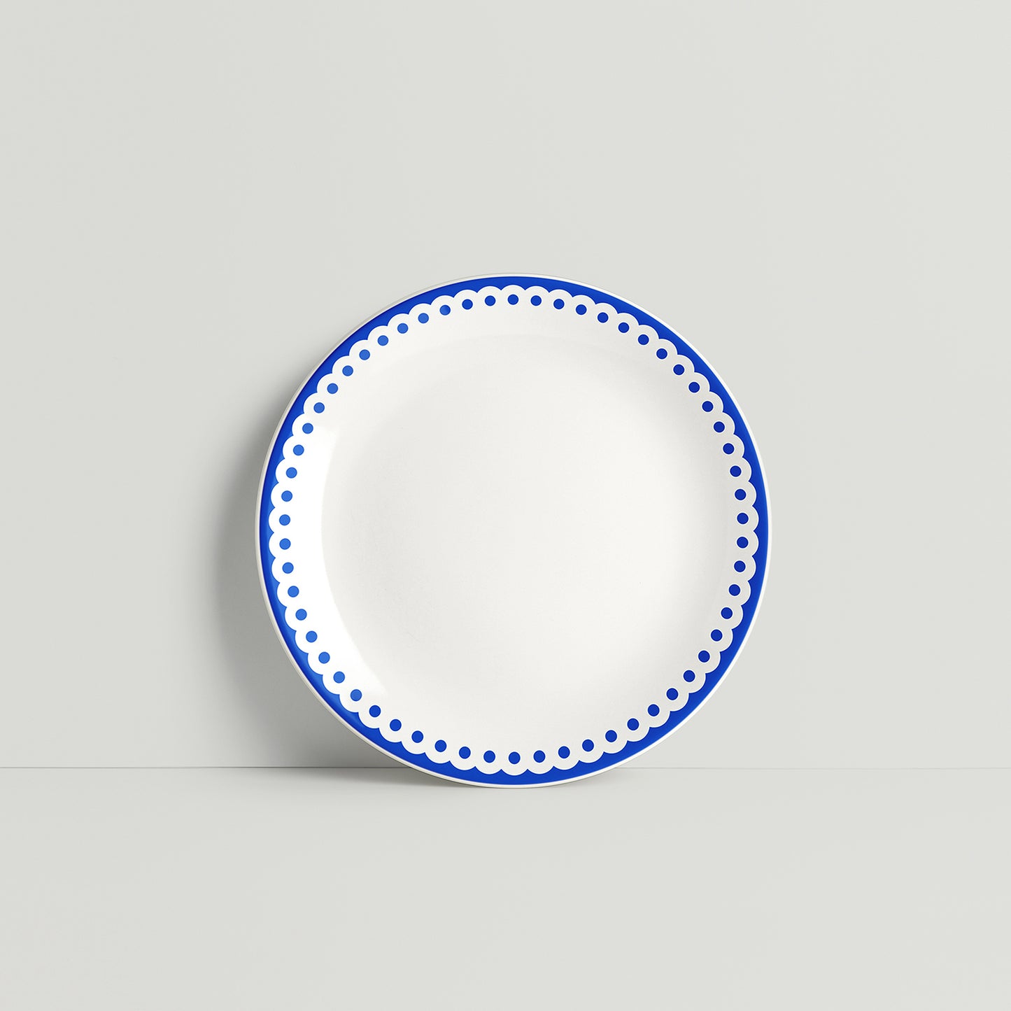 ISUWA porcelain plate with a navy blue dotted border design on a white glazed surface
