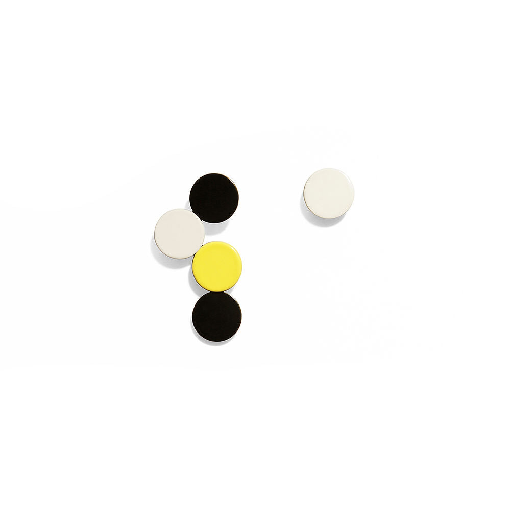 Pair of bubble earrings with vertically stacked black, yellow and white circles on a white background, showing playful modern geometry.
