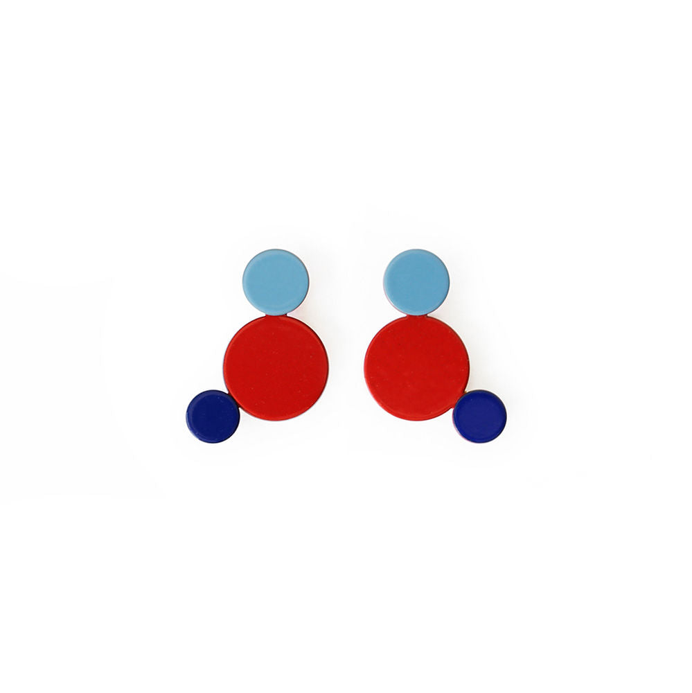 Colorful geometric earrings featuring red, sky blue and navy circles in a modern sculptural design by ISUWA.
