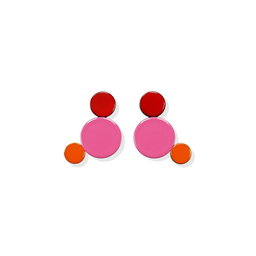 Geometric earrings in pink, red and orange with a playful sculptural design by ISUWA, photographed on a white background.

