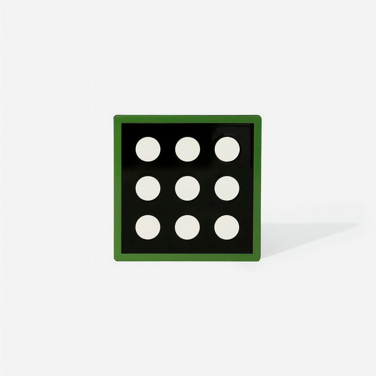 Green square metal coaster with nine white circular cut-outs and glossy green frame – handcrafted by ISUWA for modern and artistic table styling