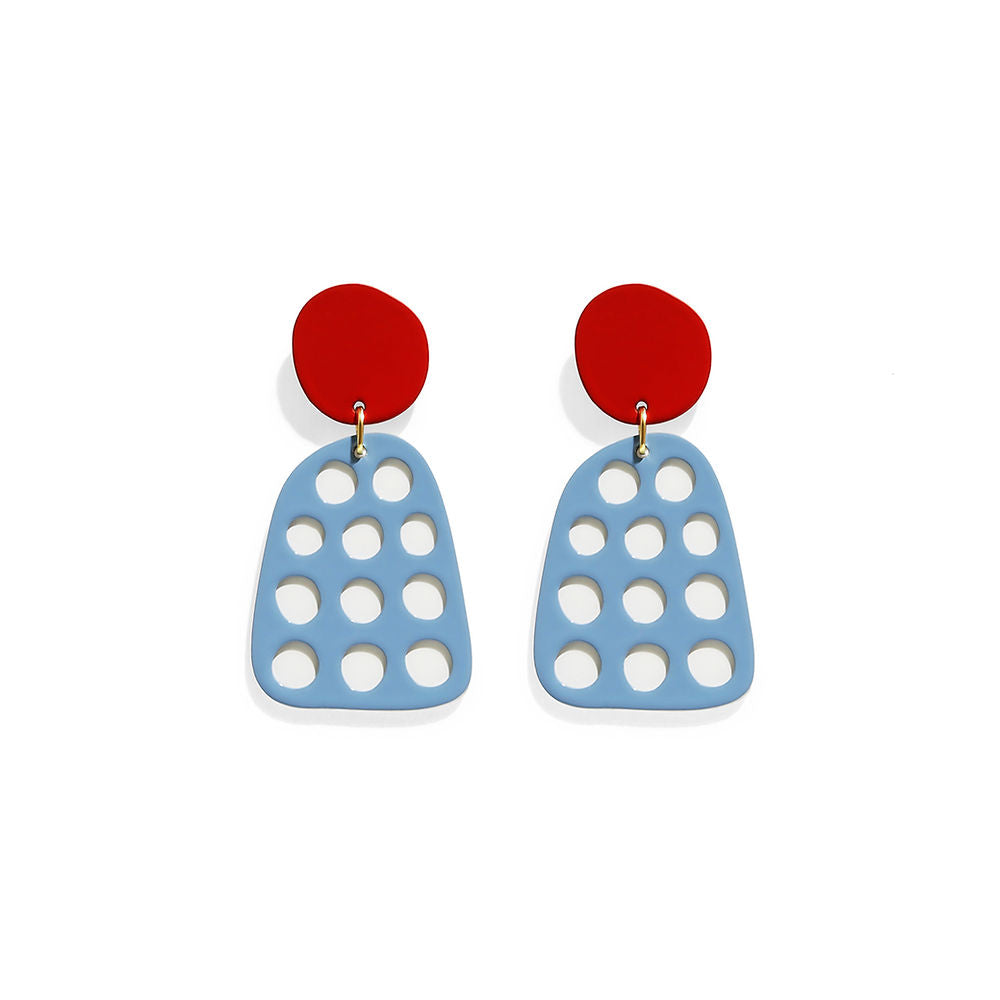 A pair of blue statement earrings with red studs and round cut-outs, photographed on a white background.
