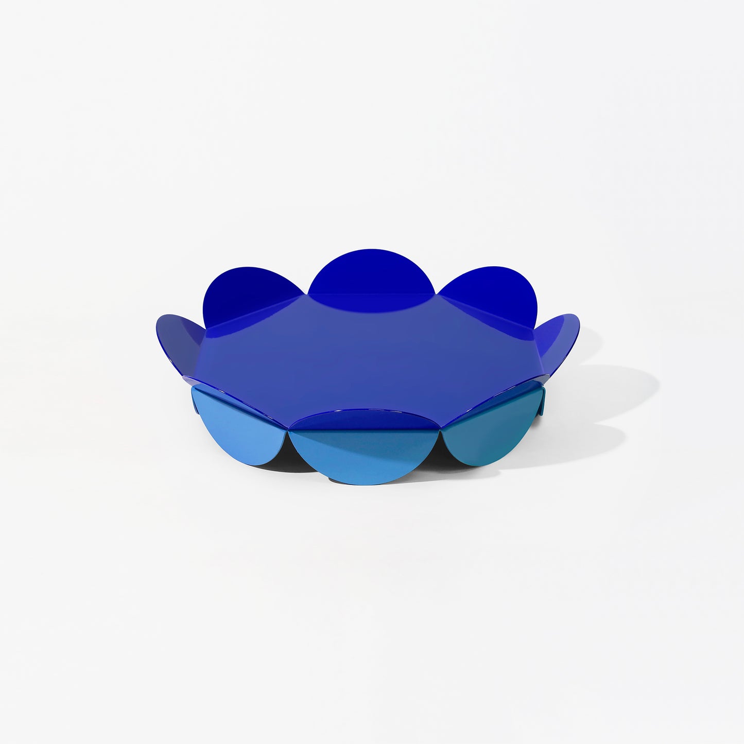 Small blue flower-shaped serving stand with petal-like edges and light blue base – compact and sculptural design by ISUWA
