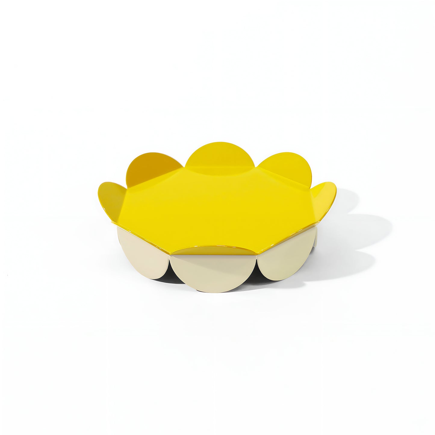 Small yellow flower-shaped serving stand with petal-like edges and a soft cream base – playful and compact design by ISUWA
