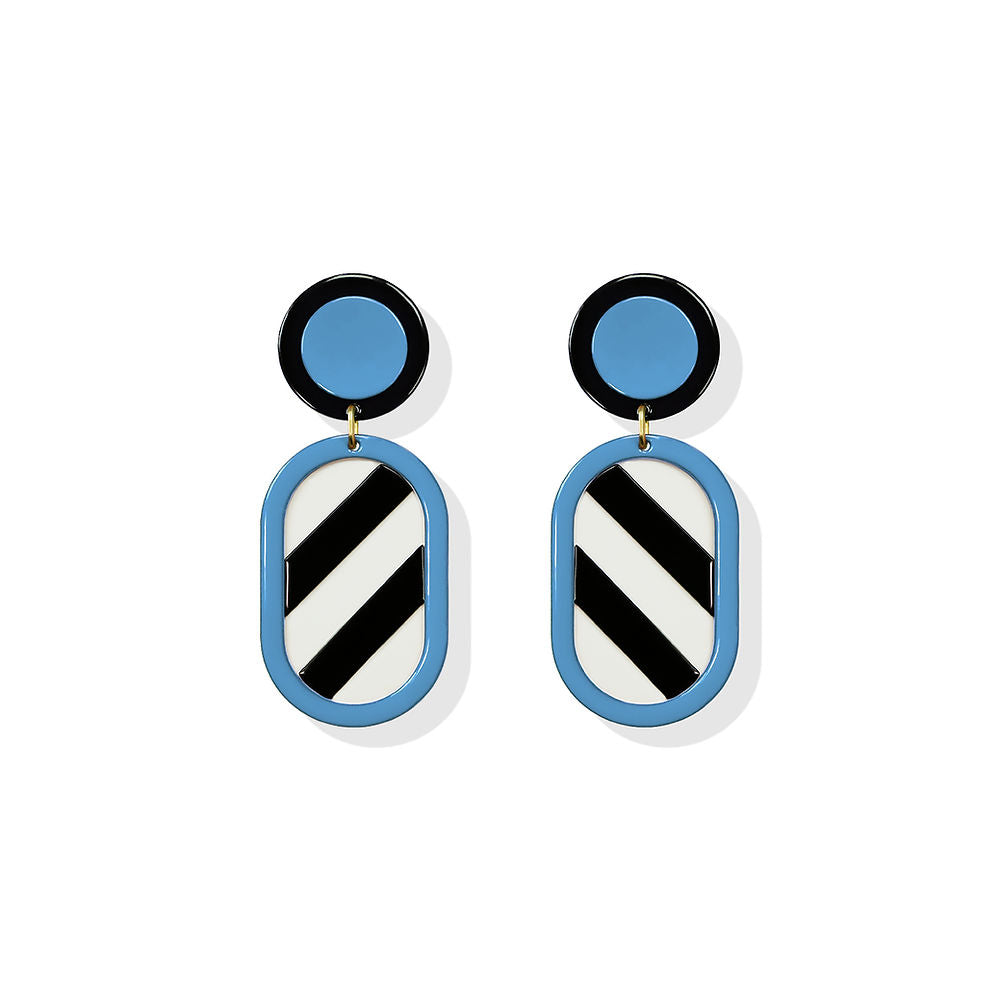 Geometric earrings with a black and white striped oval drop framed in blue and a blue-black circular top, designed by ISUWA and photographed on a white background.
