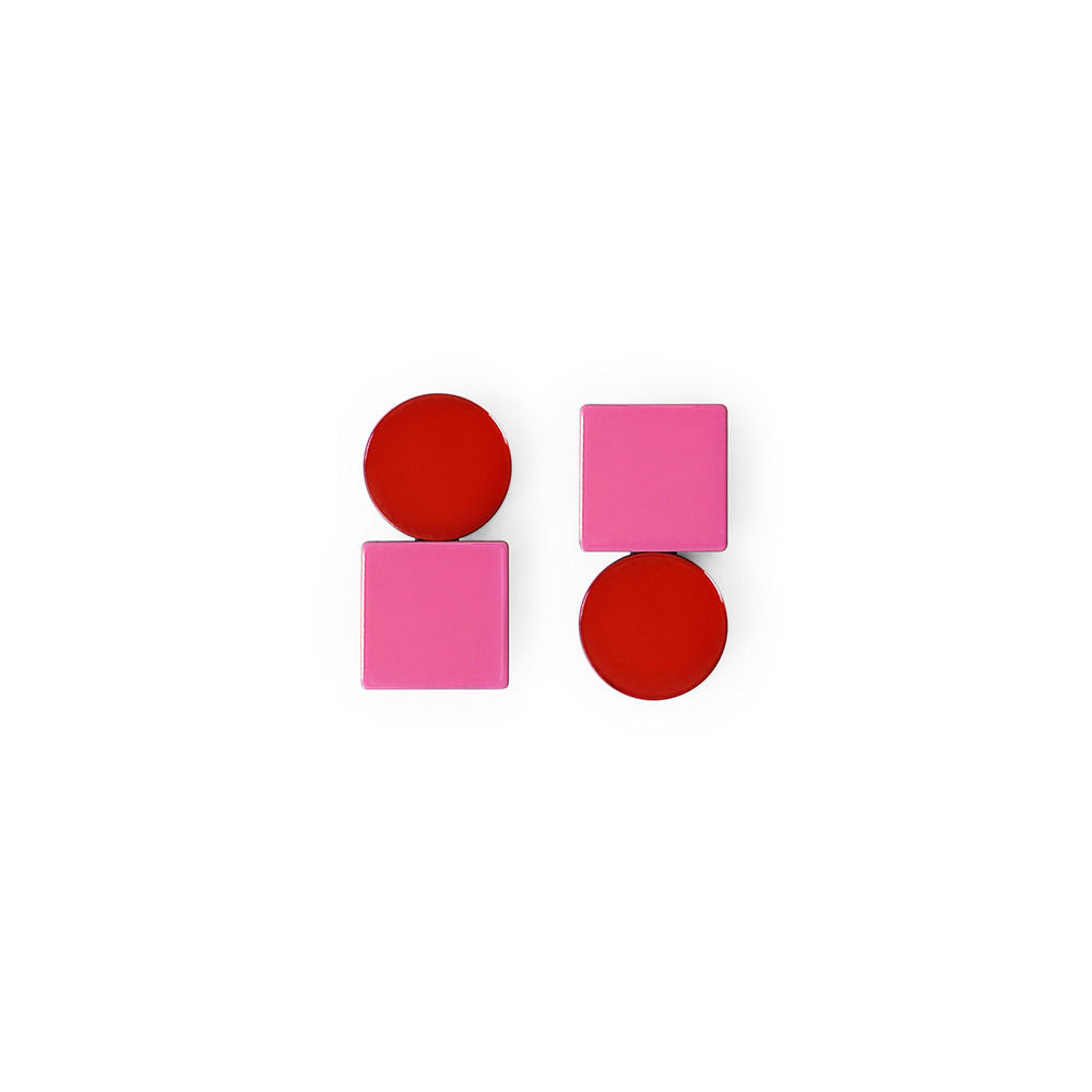 A pair of geometric earrings combining red circular and pink square shapes in a stacked, sculptural design. Glossy finish, displayed on a clean white background.
