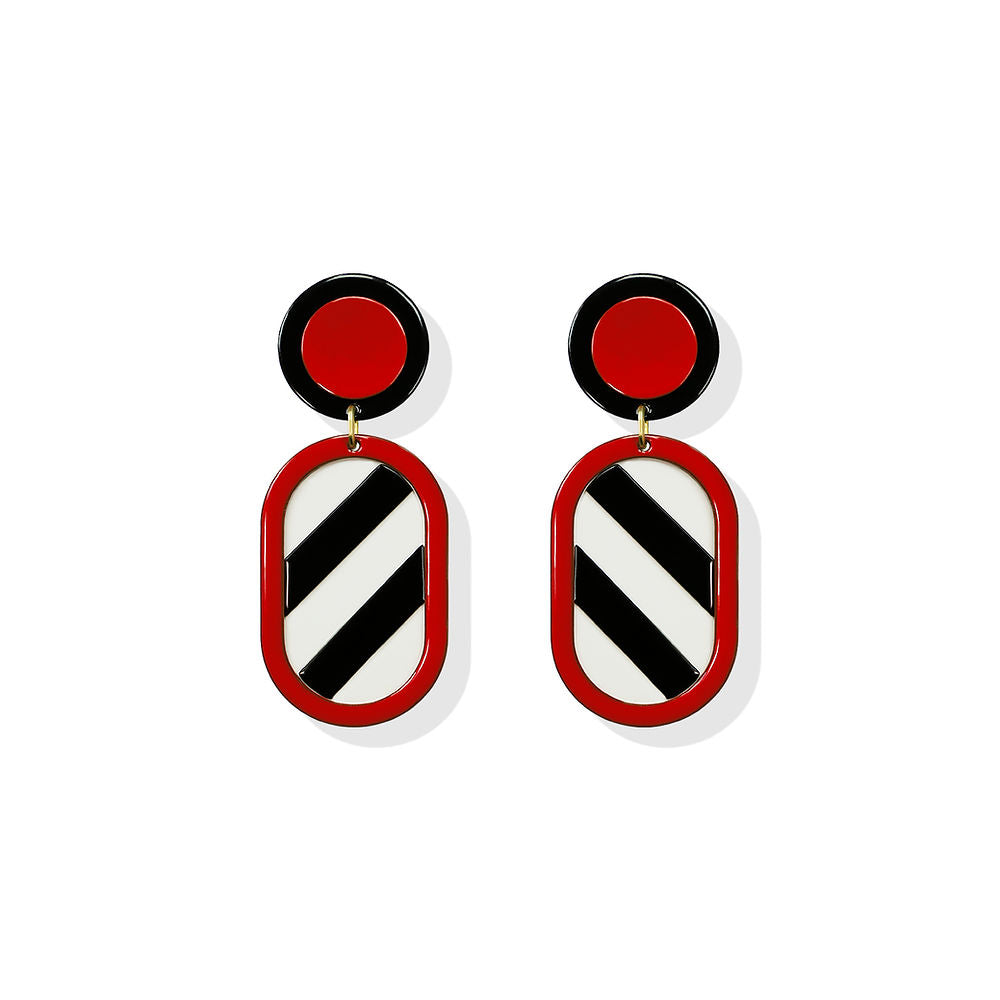 Geometric earrings featuring a black and white striped oval drop framed in red, with a red circular top, designed by ISUWA and photographed on a white background.
