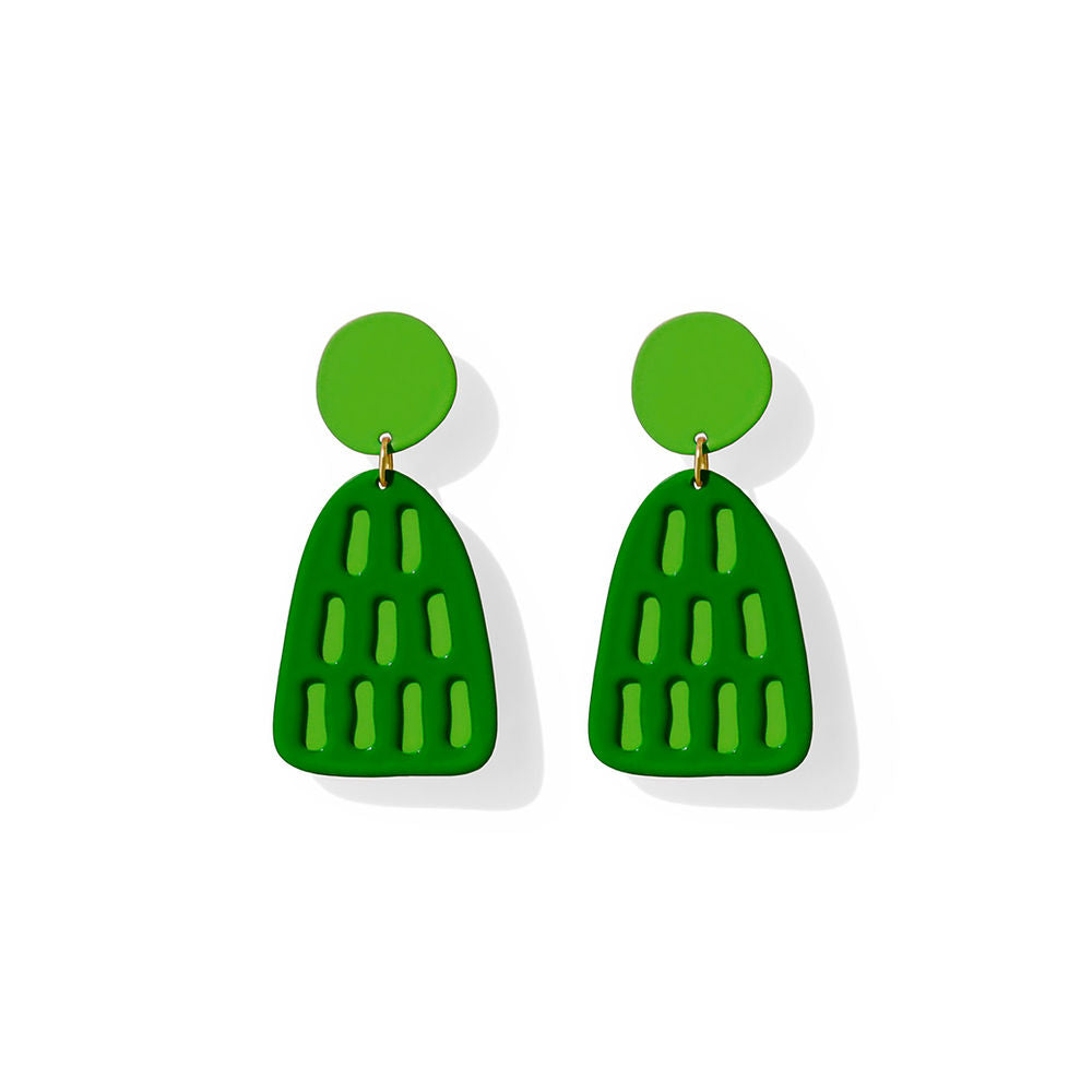 Sculptural green earrings with cut-out striped design and bold geometric shape, created by ISUWA and photographed on a white background.
