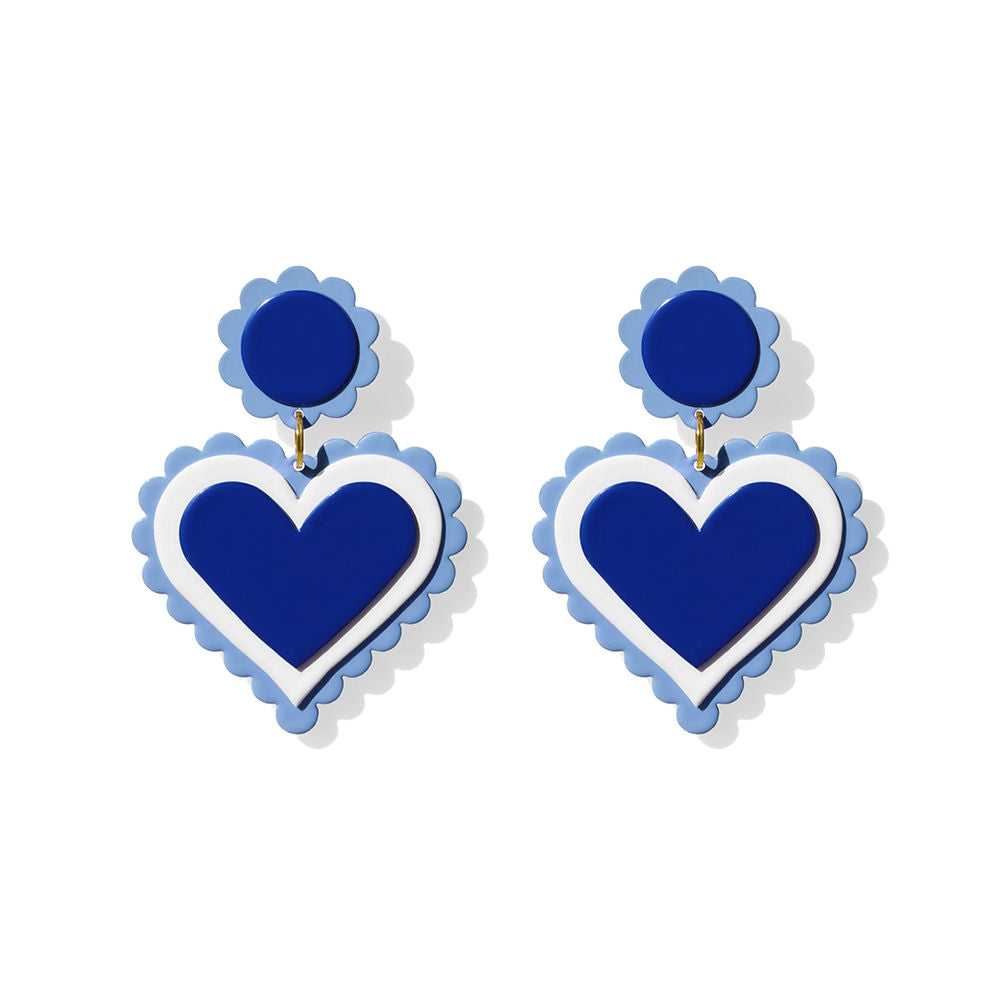Pair of bold blue heart-shaped earrings with layered navy and white hearts and sky blue scalloped edges, displayed on a white background.
