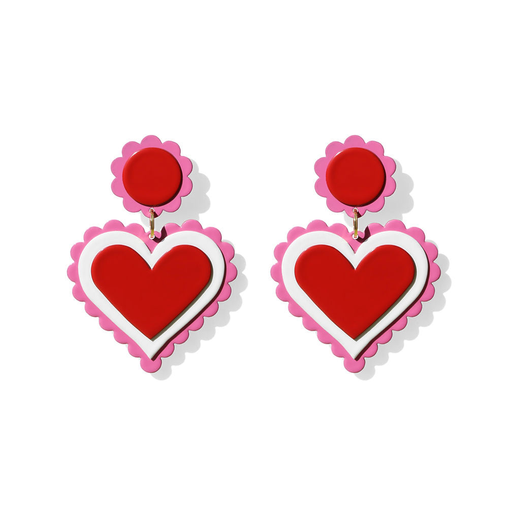 Pair of layered heart-shaped earrings in red and white, framed with pink scalloped edges, displayed on a white background.
