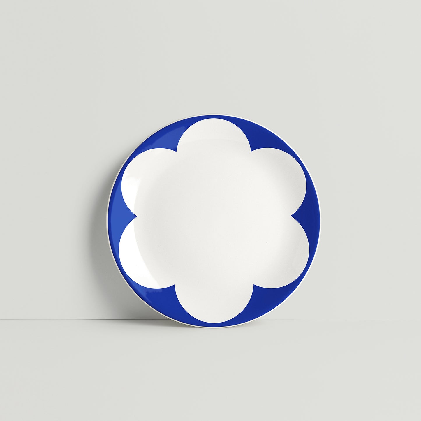 ISUWA navy porcelain plate with large white daisy petal motifs and bold graphic contrast on a minimal backdrop

