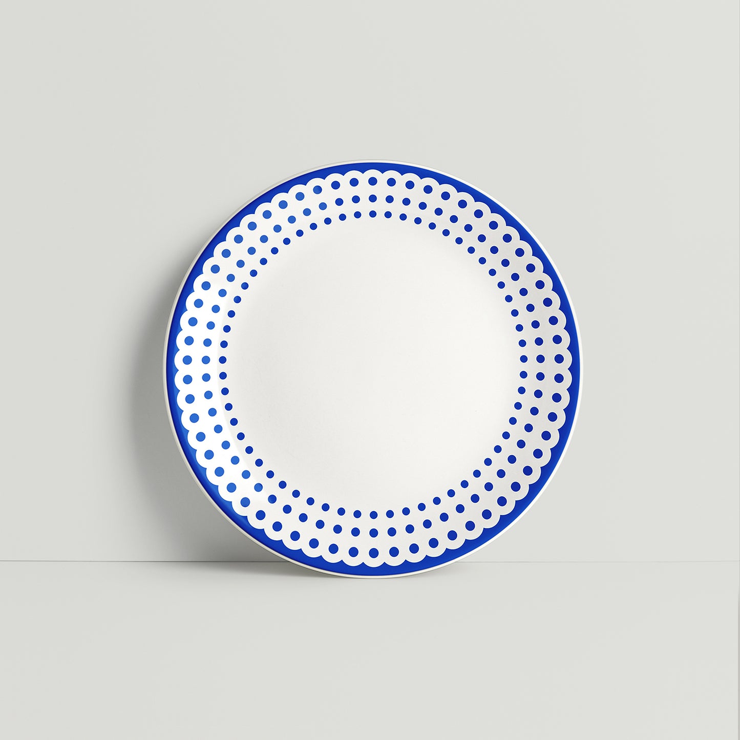 ISUWA’s large navy porcelain plate featuring a double dotted border pattern, styled on a soft gray backdrop

