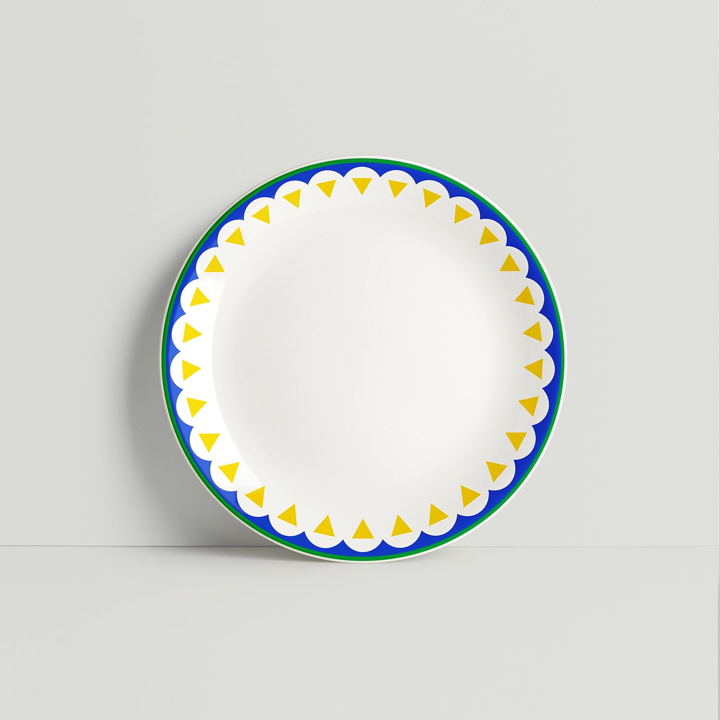 Porcelain plate with bold blue scallop and yellow triangle border design on a white background, handmade by ISUWA
