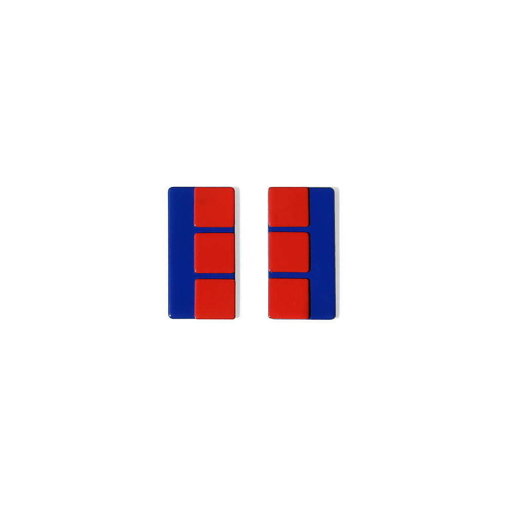 A pair of navy and red rectangular earrings with a glossy finish, featuring clean vertical lines and bold block segments. Displayed on a neutral background.

