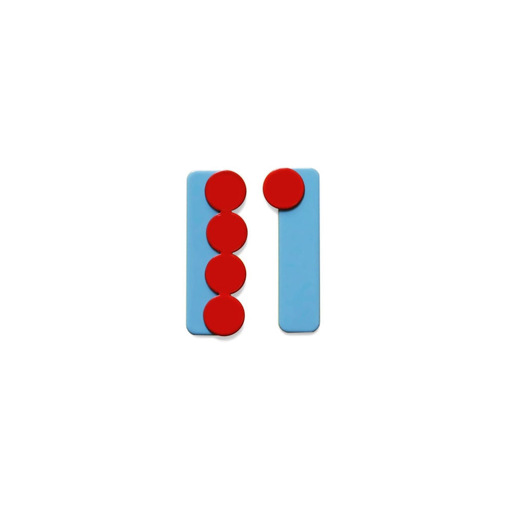 A sculptural earring featuring a vertical blue rectangle base with four glossy red circular elements stacked on top. Displayed on a white background.
