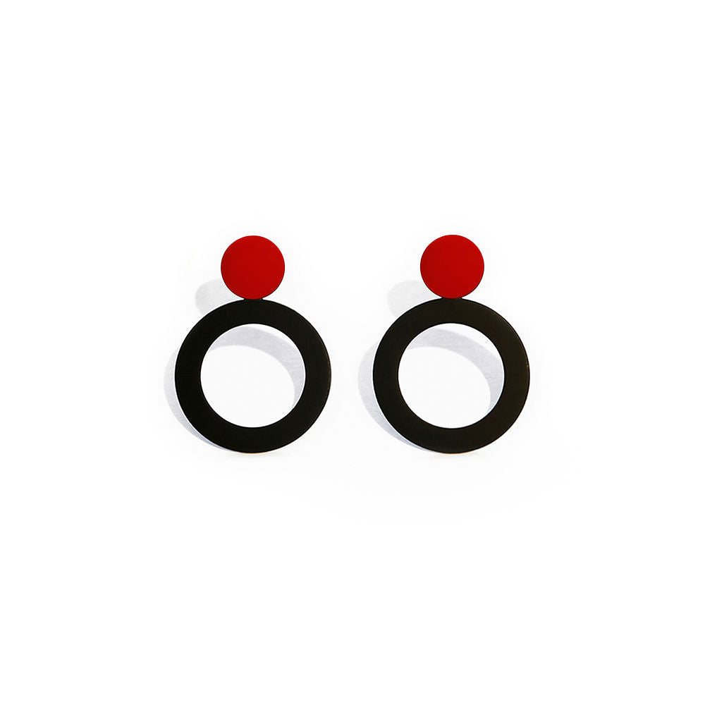 A pair of small round earrings with black circular bases and red tops, measuring 2.5x2.5 cm. The glossy, geometric design is displayed on a white background.
