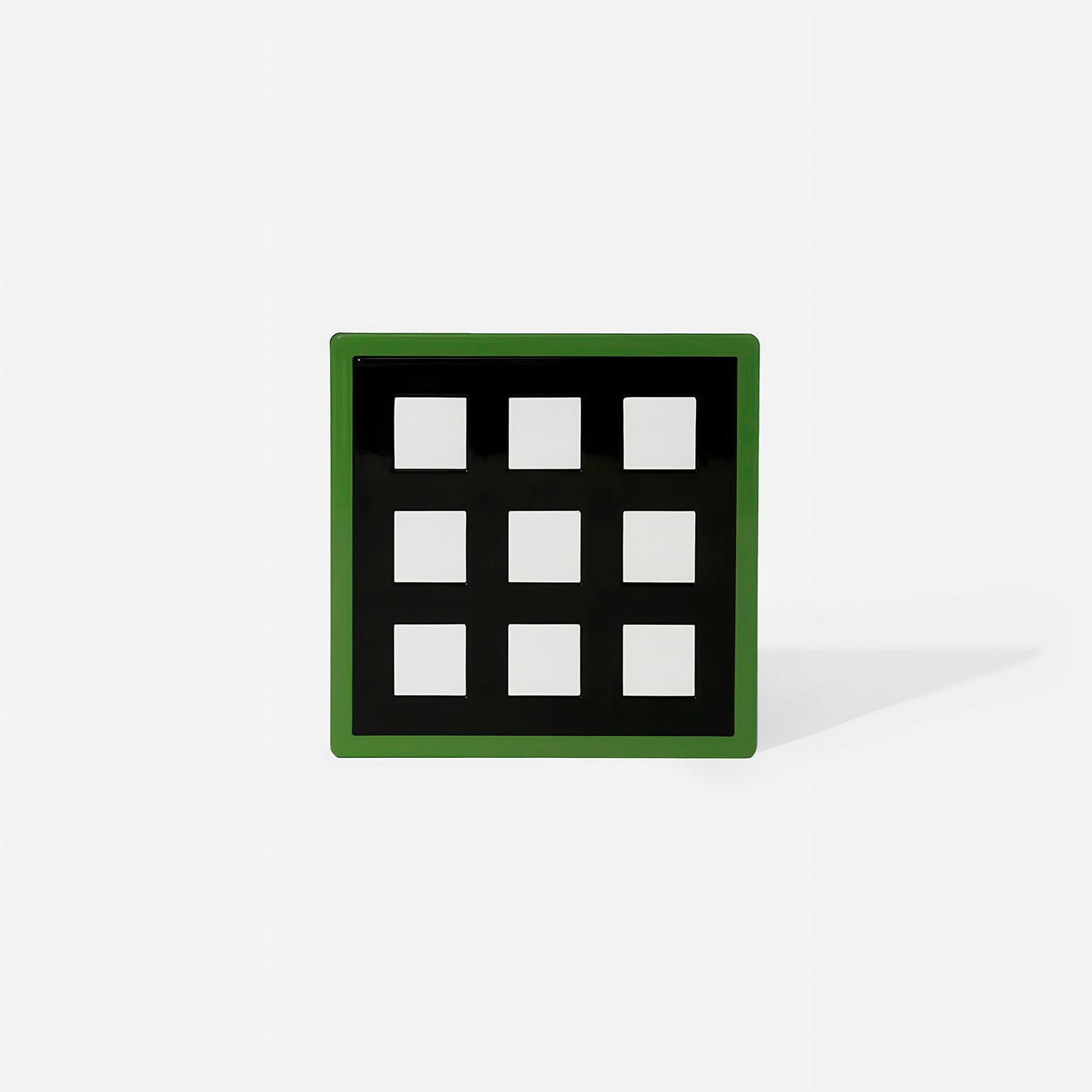 Green square metal coaster with nine white square cut-outs and glossy finish – handcrafted by ISUWA for modern and structured table styling