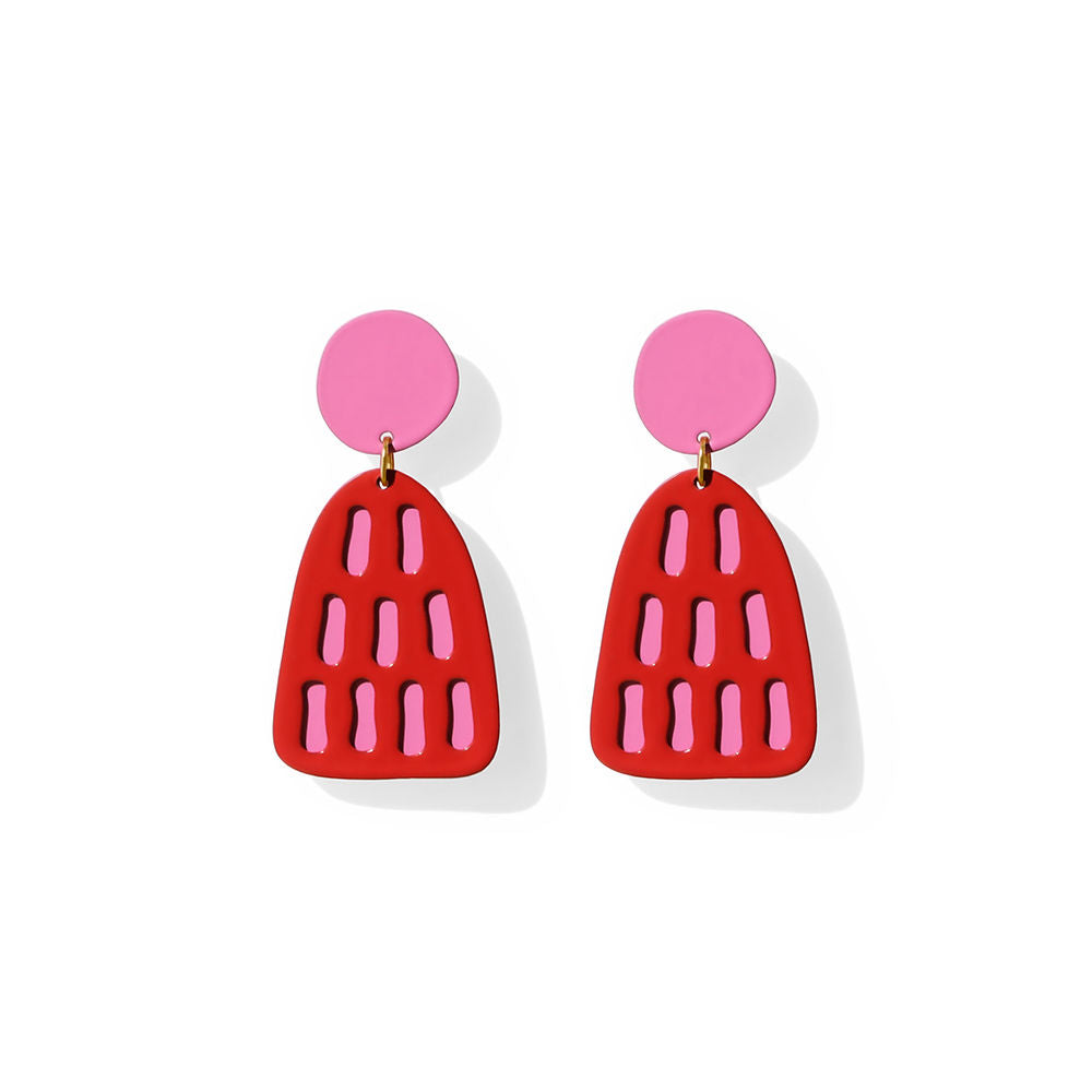 Pair of red earrings with soft pink stripe-shaped cut-outs and pink circular studs, displayed on a white background.
