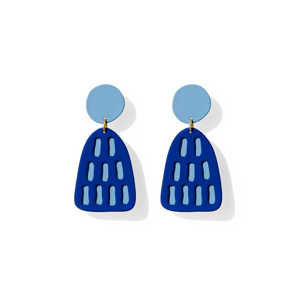 Navy trapezoid-shaped earrings with light blue stripe cutouts and a circular top, designed by ISUWA and photographed on a white background.
