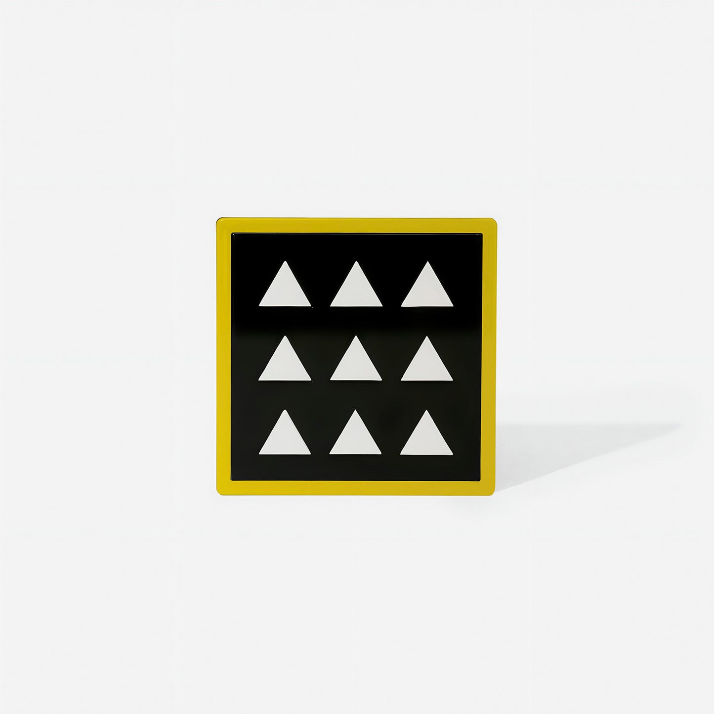 Yellow square metal coaster with nine white triangles in geometric symmetry – handcrafted by ISUWA for bold and joyful table styling