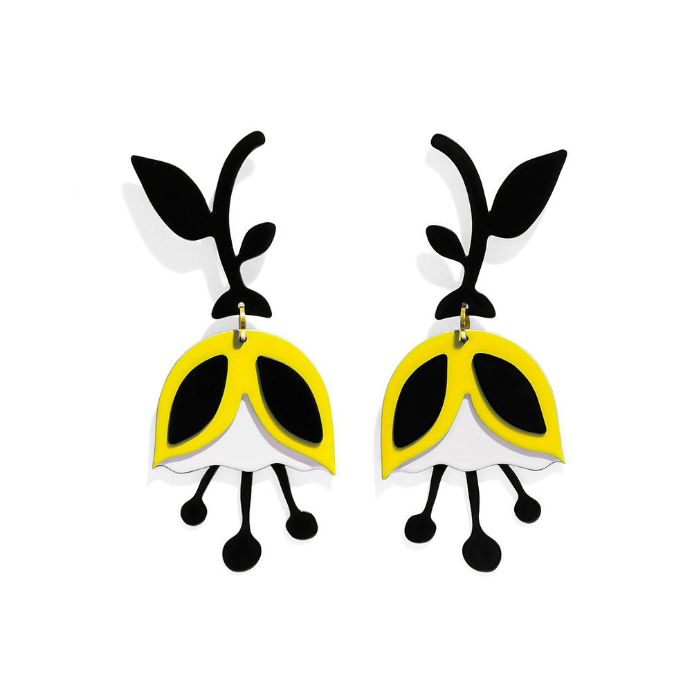 A pair of sculptural yellow tulip statement earrings with black leafy stems and playful petal layers, displayed on a white background – handmade by ISUWA.
