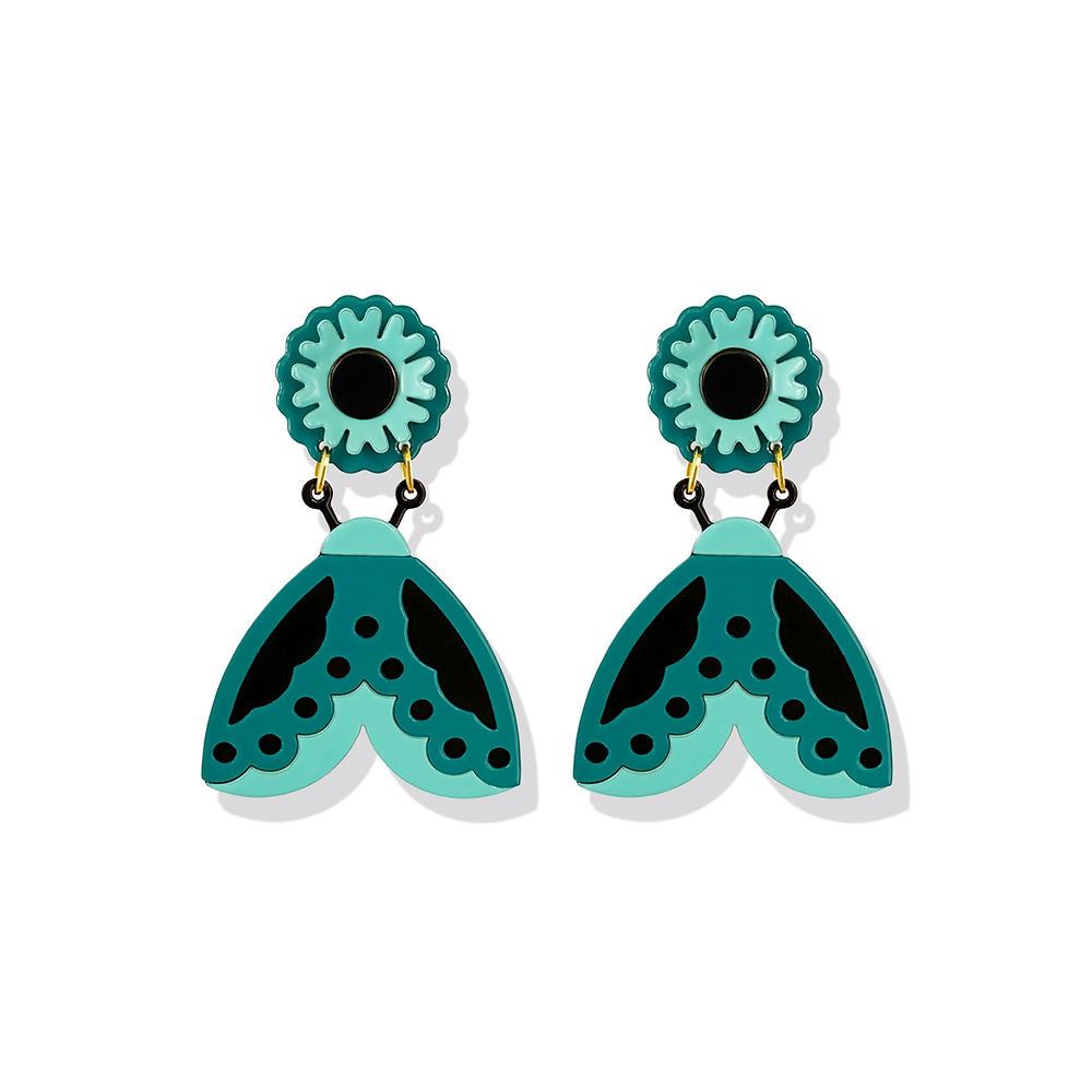 ISUWA Butterfly Earrings – artistic statement earrings in turquoise and black with floral stud details, bold geometric lines, and playful contemporary design, displayed on a white background.