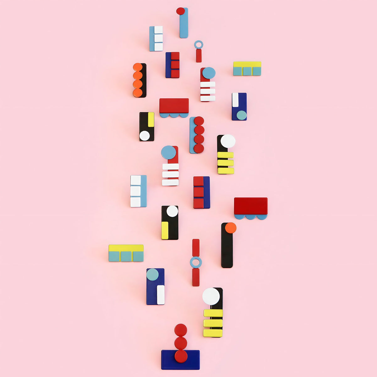 Collection of ISUWA geometric earrings in bold colors and graphic shapes, arranged on a soft pink background.