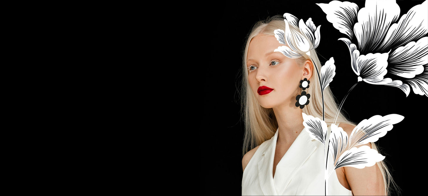 Model wearing bold black and white flower earrings on black background, with artistic floral illustrations – ISUWA jewelry