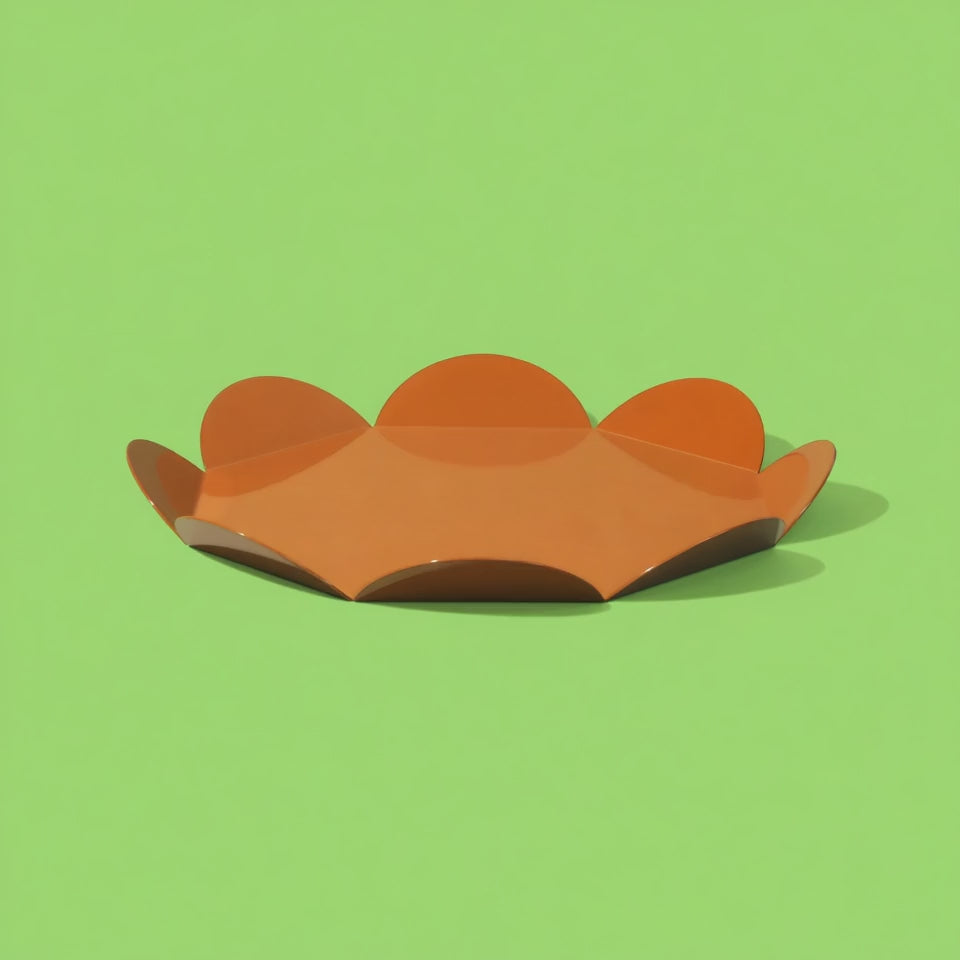 360-degree rotating video of ISUWA’s orange flower tray highlighting its sculptural petal-like form and glossy finish against a vibrant green background.
