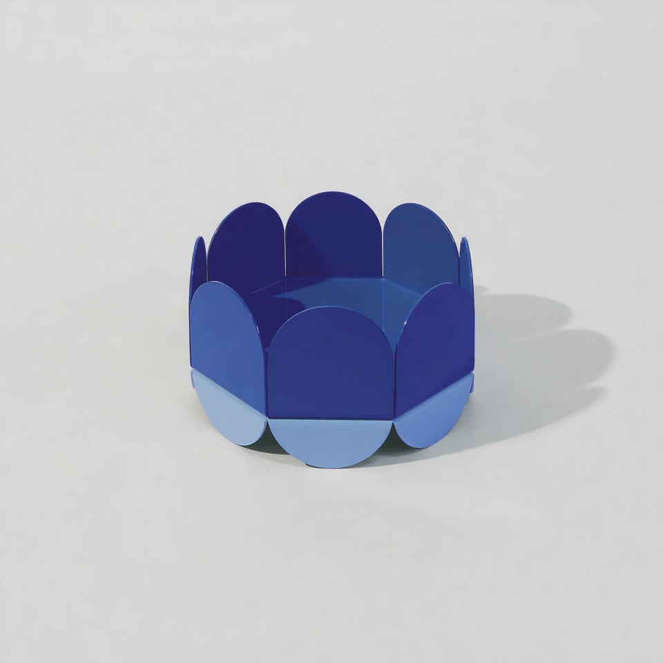 A small glossy ISUWA Blue Wave Bowl rotates 360 degrees, revealing its layered curved panels in deep and light blue tones. Sculptural, modern, and quietly elegant in motion.