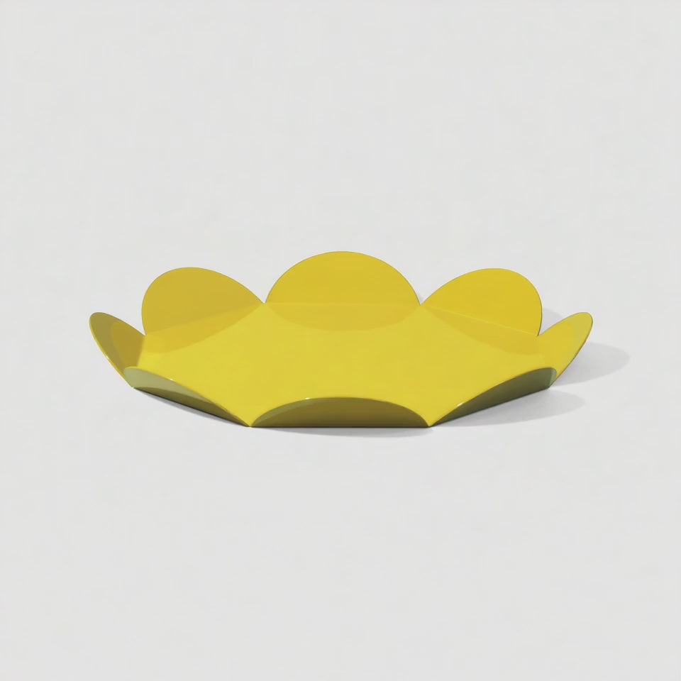 A rotating yellow flower-shaped metal tray with a glossy finish. The video highlights the curved petal edges and reflective surface as it turns on a white background.
